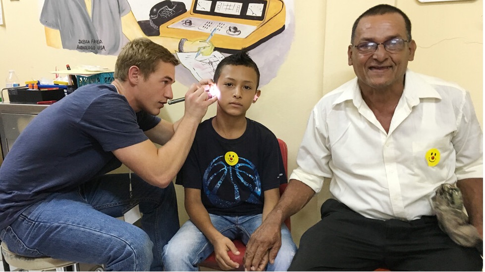 Chad Bailey (left) checks the ears of an adolescent in Nicaragua in 2016.