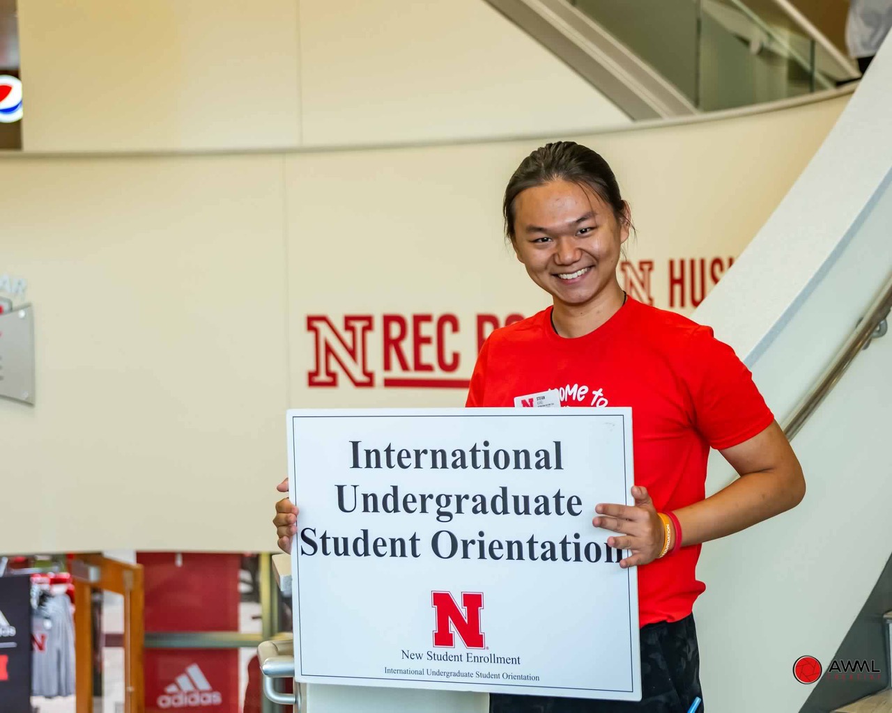 Kang in orientation holding a sign